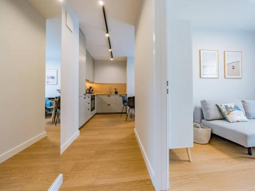 a living room with a couch and a kitchen at Hello Apartments RIO with private parking in Gdańsk