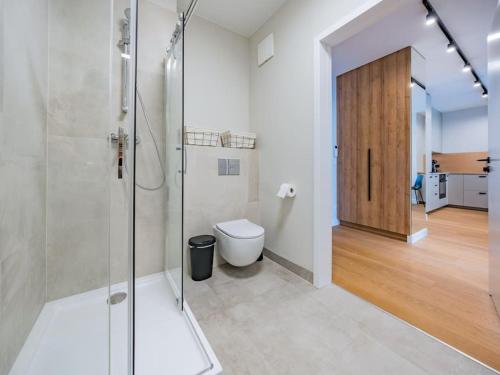 een badkamer met een glazen douche en een toilet bij Hello Apartments RIO with private parking in Gdańsk