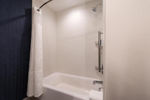 Fairfield Inn & Suites by Marriott Fort Worth Southwest at Cityview في فورت وورث: حمام أبيض مع حوض استحمام ودش