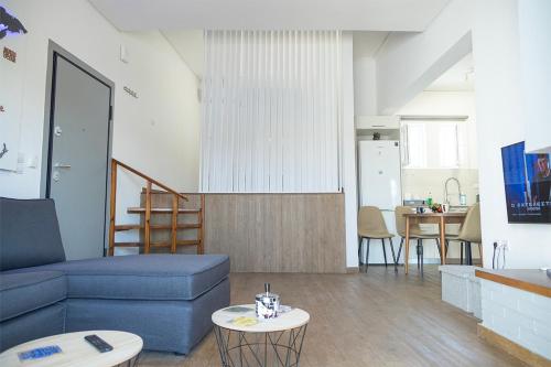 - un salon avec un canapé bleu et une table dans l'établissement Sea Front Sophia Porto Rafti, à Pórto Ráfti