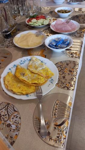 a table with plates of food and utensils on it at RB Bed & Breakfast in Gaiba