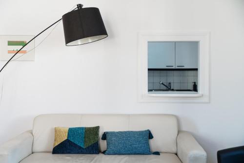 a living room with a white couch and a window at Giuka Apartment by Quokka 360 - close to the station in Massagno