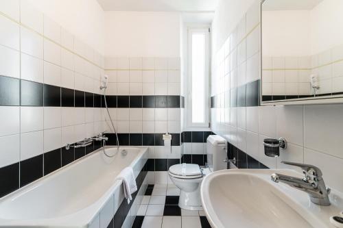 a bathroom with a tub and a toilet and a sink at Giuka Apartment by Quokka 360 - close to the station in Massagno