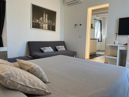 a bedroom with a bed and a couch at SirmioneRooms in Sirmione