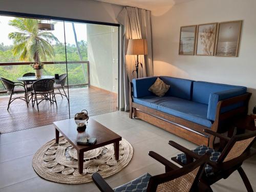 a living room with a blue couch and a table at apto vista mar imbassai in Imbassai