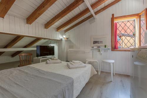 Una habitación blanca con una cama y una ventana. en Aposa Little House, en Bolonia