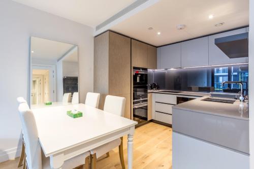 - une cuisine avec une table blanche et des chaises blanches dans l'établissement Stylish 2 Bed Flats Near US Embassy, à Londres