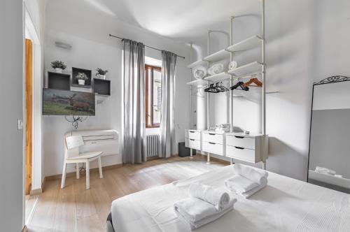 a white bedroom with a bed and a desk at Giardino della Fortezza & San Lorenzo Central Flat in Florence