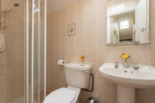 een badkamer met een toilet, een wastafel en een spiegel bij City Center-3 min Walk to Town Square in Galway