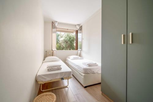 une petite chambre avec deux lits et une fenêtre dans l'établissement Magnifique appartement T3 centre Cannes, à Cannes