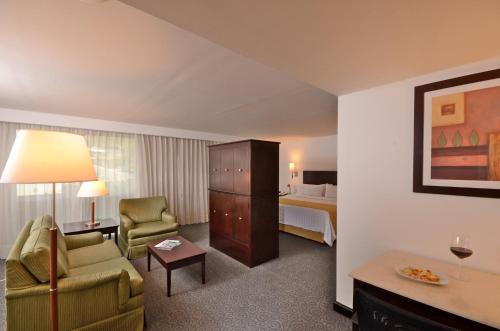 a hotel room with a bed and a living room at Holiday Inn Monterrey Valle by IHG in Monterrey