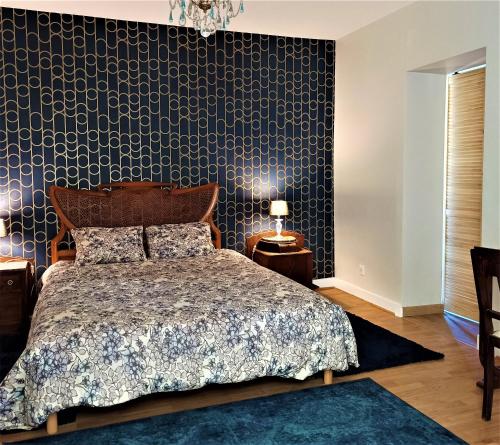 a bedroom with a bed and a black wall at Villa Lortin in Pouillon