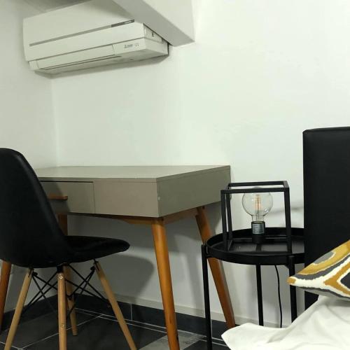 a desk with two chairs and a light on a wall at Penthouse 120 m2 vue imprenable Lattes in Lattes