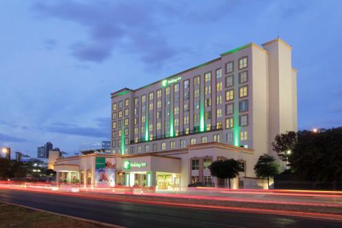 um edifício de hotel com luzes verdes numa rua da cidade em Holiday Inn Monterrey Valle, an IHG Hotel em Monterrey