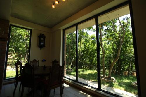 a dining room with a table and large windows at Villa Vejini in Mamkoda