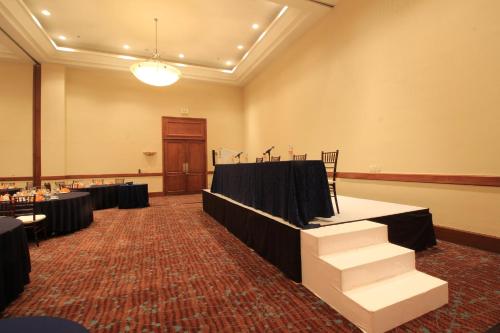 a conference room with tables and chairs and a stage at Holiday Inn Monterrey Valle by IHG in Monterrey