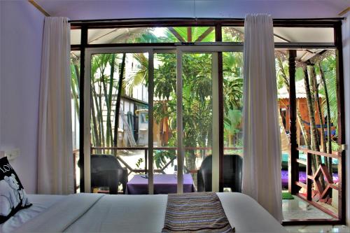 a bedroom with a bed and a large glass window at Sai Valentines in Canacona