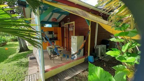 a porch of a house with a refrigerator at TI-COLIBRI in Saint-Claude