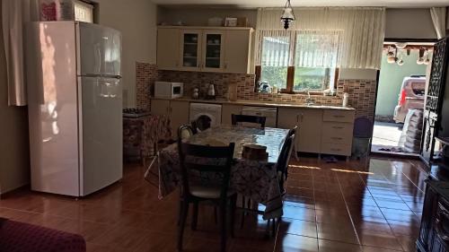 Ayten's Sweet House في طرابزون: مطبخ مع طاولة مع كراسي وثلاجة