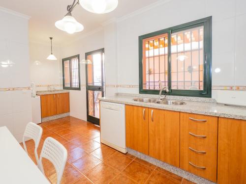 eine Küche mit einer Spüle sowie einem Tisch und Stühlen in der Unterkunft Cubo's Casa Ronda del Olivar in Pizarra