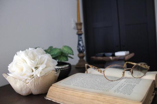 a book with a flower and glasses on a table at Praga in Serravalle Scrivia