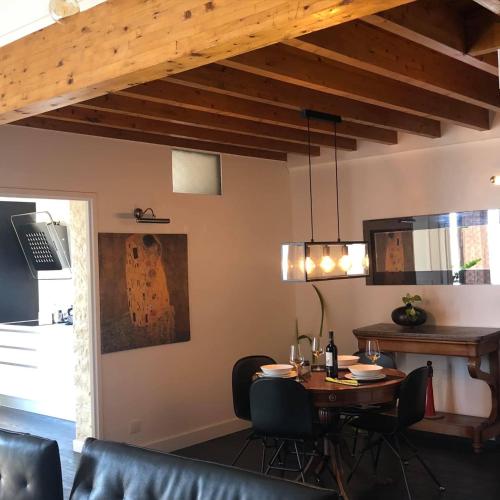 a dining room with a table and chairs and a ceiling at Penthouse 120 m2 vue imprenable Lattes in Lattes