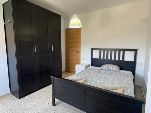 1 dormitorio con 1 cama y armario negro en UIM Mediterraneo Emilio Llopis Wifi, en Sagunto