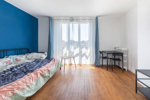 1 dormitorio con cama, mesa y ventana en Cénoslocs - Paris à vos pieds pour 6 pers., en Noisy-le-Sec
