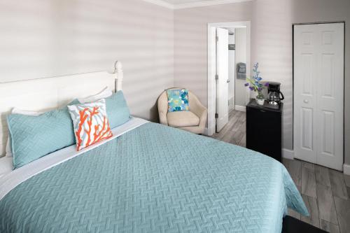 a bedroom with a large bed and a chair at Emerald on the Water - Formerly Belleair Beach Club in Clearwater Beach