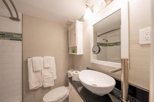 a bathroom with a sink and a toilet and a mirror at Emerald on the Water - Formerly Belleair Beach Club in Clearwater Beach