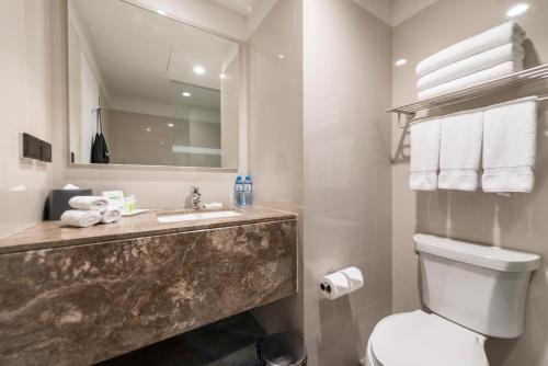a bathroom with a sink and a toilet and a mirror at Holiday Inn - Lima Airport by IHG in Lima