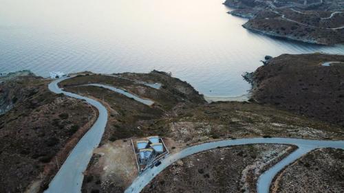 a winding road on a hill next to the water at MYRTOS in Karistos