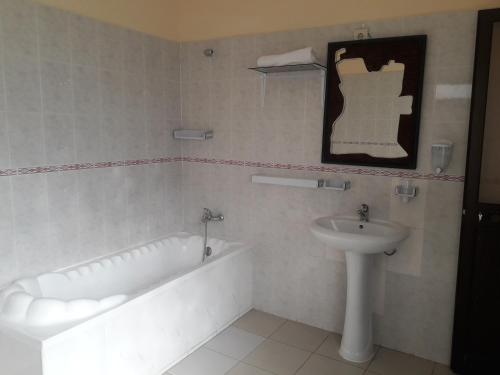a bathroom with a bath tub and a sink at CHIP RESIDENCIAL in Luanda