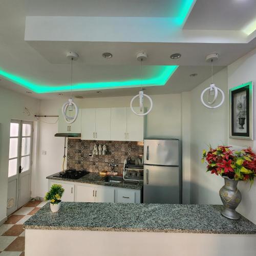 a kitchen with green lights on the ceiling at Résidence Novostar in Chott Meriem