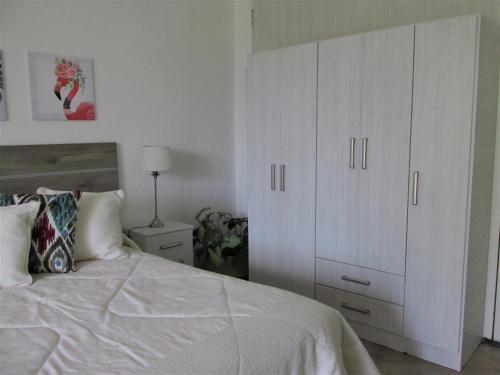 una camera con un letto bianco e un grande armadio bianco di Habitación doble, baño privado. a Maipú