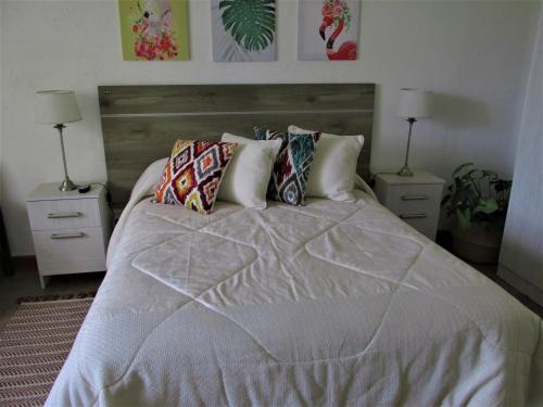 a bedroom with a large bed with two night stands at Habitación doble, baño privado. in Maipú