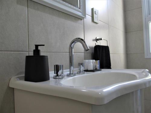 a bathroom sink with a soap dispenser on it at Habitación doble, baño privado. in Maipú