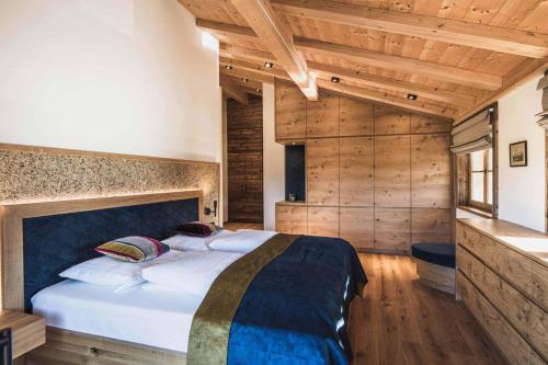 a bedroom with a large bed in a room with wooden walls at Chalet am Wetterkreuz in Reit im Winkl