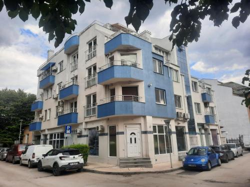 a blue building with cars parked in front of it at MDM APARTMENT CITY CENTER in Ruse