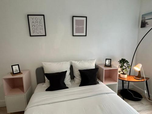 1 dormitorio con 1 cama con sábanas y almohadas blancas en Cosy appartement Boulogne en Boulogne-Billancourt