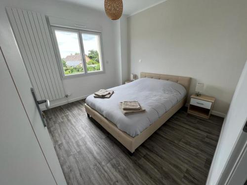 a white bedroom with a bed and a window at Maison Rénovée Aux Portes Du Circuit Des 24h in Mulsanne