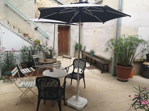 a table and chairs with an umbrella on a patio at Au Terminus 6 Personnes in Hautvillers