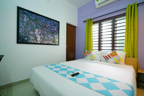 una camera da letto con un letto e una TV a parete di Kaippillil apart hotel a Ernakulam