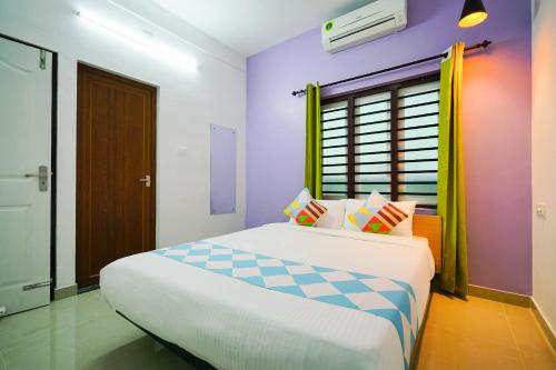una camera da letto con un letto grande con pareti viola di Kaippillil apart hotel a Ernakulam