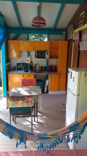 a kitchen with a table and a refrigerator at TI-COLIBRI in Saint-Claude