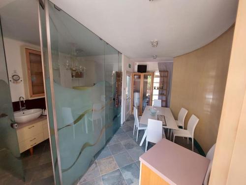 une cuisine avec une douche en verre, une table et des chaises dans l'établissement casa di marco, à Ravenne