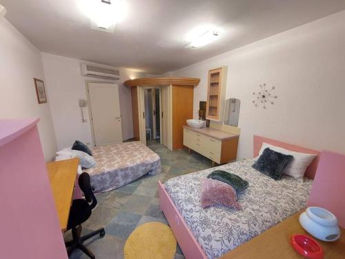 - une chambre avec 2 lits, un bureau et une commode dans l'établissement casa di marco, à Ravenne