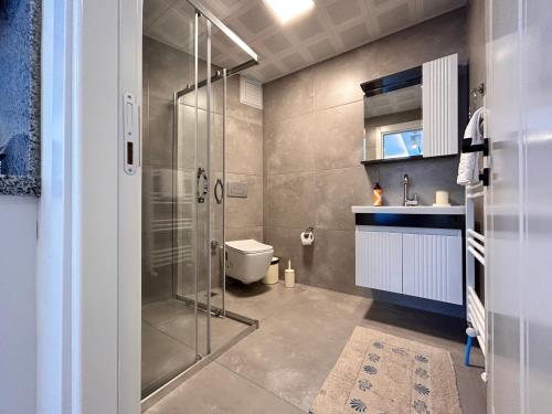 a bathroom with a shower and a toilet and a sink at HADRİANS TOWER in Antalya