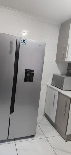 una cucina con frigorifero in camera di Bozi Abode a Kempton Park