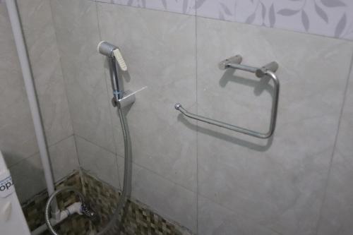 La salle de bains est pourvue d'une douche et d'un tuyau mural. dans l'établissement Sparrow Nest Homestay, à Darjeeling